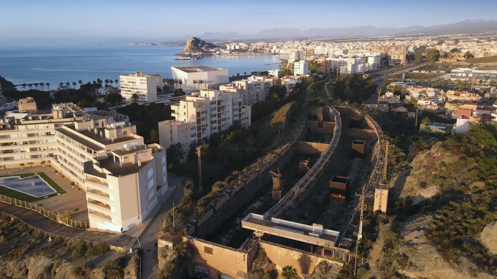 Vía Verde del Embarcadero del Hornillo en Águilas: pasarela peatonal y cargadero metálico de mineral de hierro proyectándose sobre la bahía del Mediterráneo, con la Isla del Fraile al fondo.