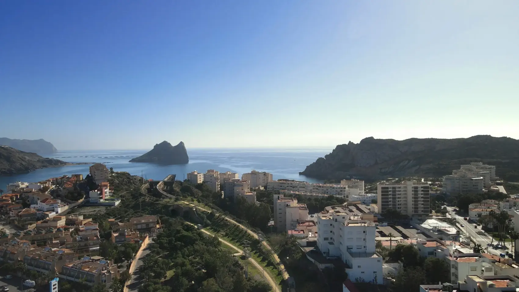 Vía Verde del Embarcadero del Hornillo en Águilas: pasarela peatonal y cargadero metálico de mineral de hierro proyectándose sobre la bahía del Mediterráneo, con la Isla del Fraile al fondo.