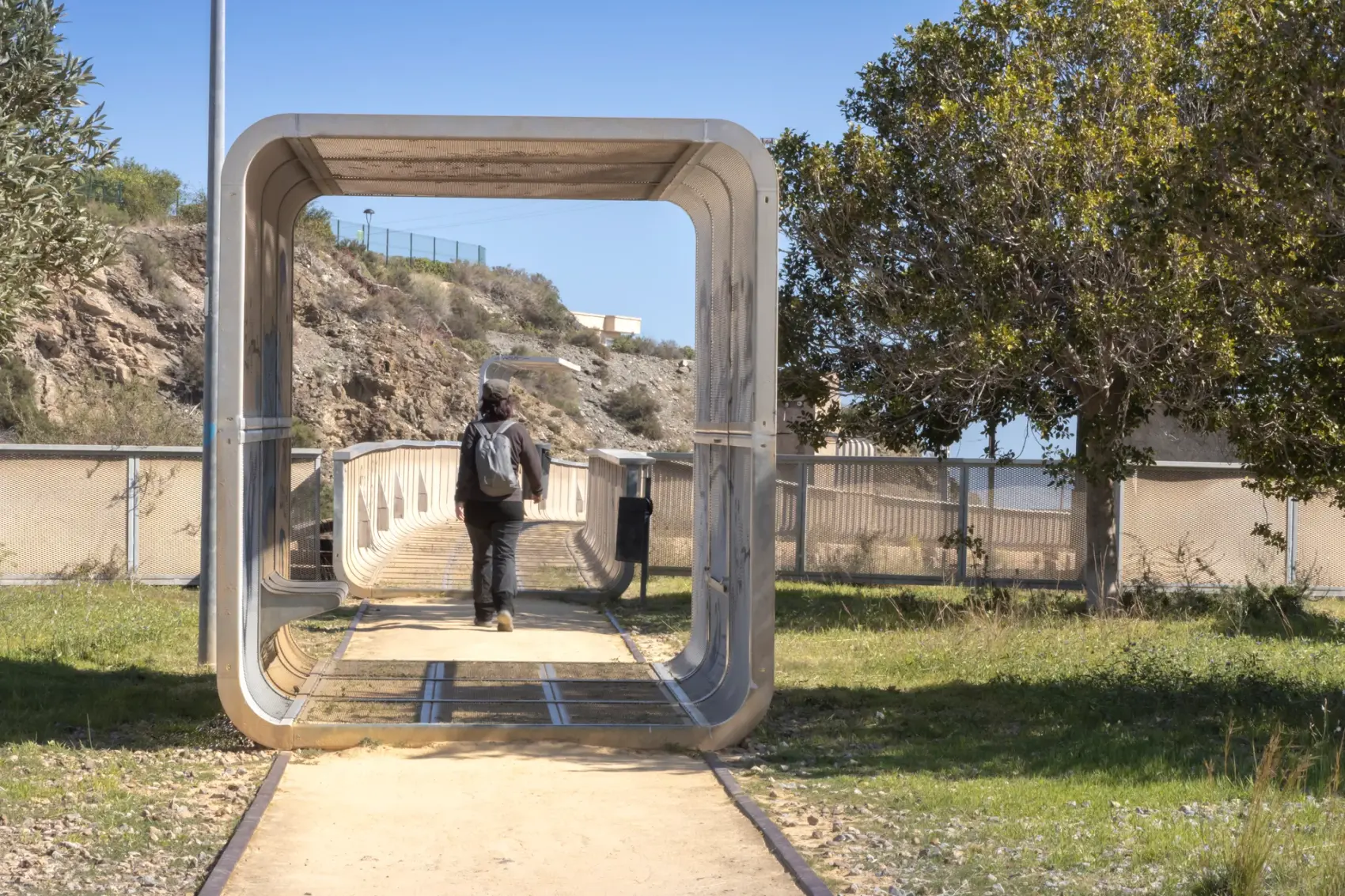 Vía Verde del Embarcadero del Hornillo en Águilas: pasarela peatonal y cargadero metálico de mineral de hierro proyectándose sobre la bahía del Mediterráneo, con la Isla del Fraile al fondo.