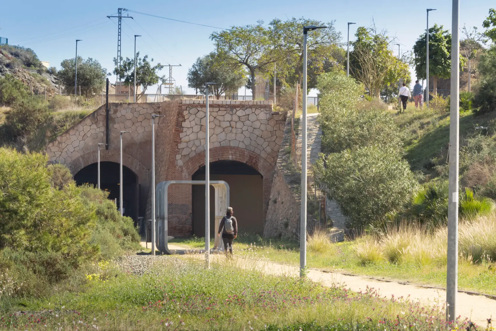 Vía Verde del Embarcadero del Hornillo en Águilas: pasarela peatonal y cargadero metálico de mineral de hierro proyectándose sobre la bahía del Mediterráneo, con la Isla del Fraile al fondo.