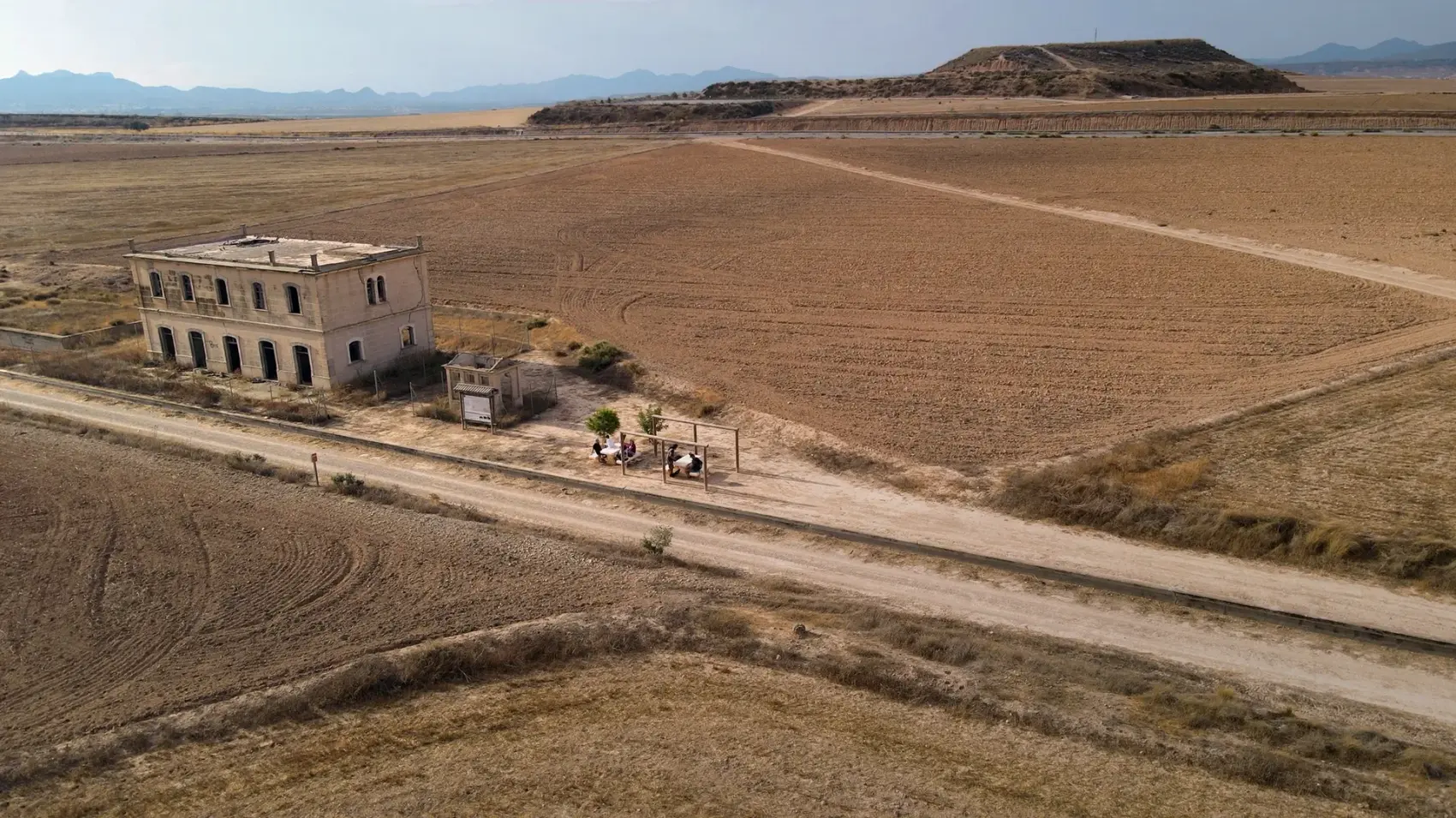 Puente de fábrica sobre el cauce del río Guadalentín, principal obra del antiguo trazado ferroviario Totana-Cartagena, visto entre los frutales del Campo de Cartagena bajo cielo despejado